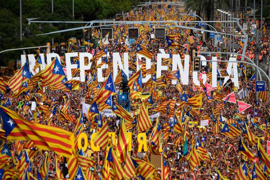 People wave pro-independence Catalan flags 'Esteladas' while holding letters reading 'independence' during a pro-independence demonstration in Barcelona, Spain