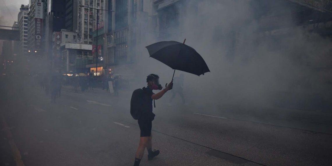 A protester reacts from tear gas fired by police during a 2019 pro-democracy march in Hong Kong