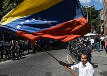 A man holding a Venezuelan national flag during a protest against President Nicolas Maduro.