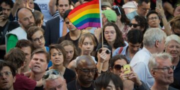 People wave flags during a vigil in reaction to the mass shooting at a gay nightclub in Orlando, Florida on June 12, 2016. Photo: Bryan R. Smith/AFP via Getty Images