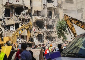 Rescuers sift through the rubble at the scene of an Israeli strike that targets Beirut's southern suburbs