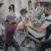 Men pass a young girl to safety over rubble in Jabalia Refugee Camp, Gaza Strip, on May 18, 2025. Search and rescue teams rescue a Palestinian girl from under the rubble after the Israeli army attacked a building at the Jabalia Refugee Camp